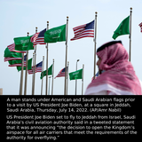 Mungkin imej 1 orang dan teks yang berkata '歡发 A man stands under American and Saudi Arabian flags prior to a visit by US President Joe Biden, at a square in Jeddah, Saudi Arabia, Thursday, July 14, 2022. (AP/Amr Nabil) US President Joe Biden set to fly to Jeddah from Israel, Saudi Arabia's civil aviation authority said in a tweeted statement that it was announcing "the decision to open the Kingdom' S airspace for all air carriers that meet the requirements of the authority for overflying."'